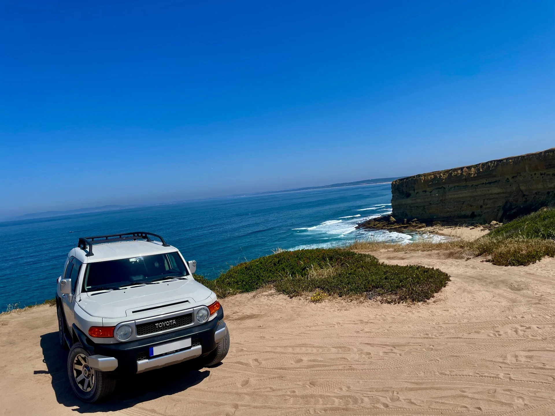 Toyota FJ Cruiser and travelers near Atlantic cliffs